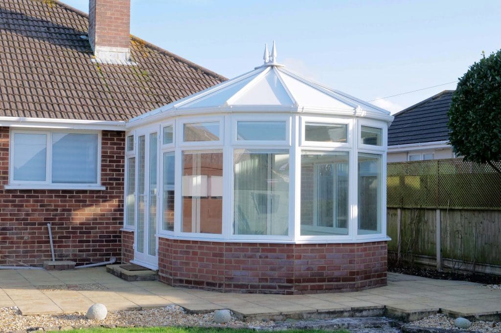 Gallery image of a house with a white roof and a brick wall.